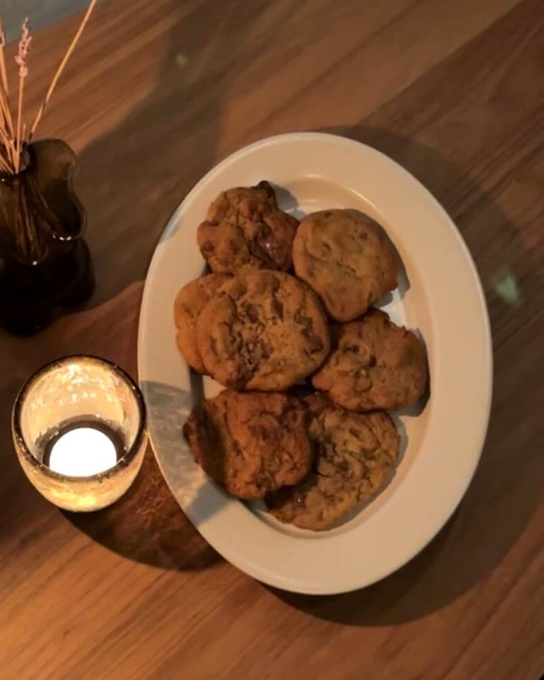 Nystekte cookies på et fat, ved siden av et telys